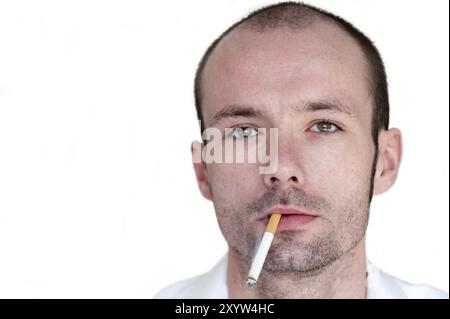 Young man with a cigarette in the corner of his mouth Stock Photo