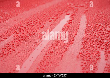 Closeup waterdrops on red ceramic coated paint surface, shallow focus Stock Photo
