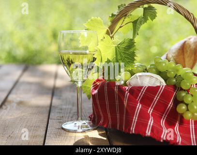 Cheese, grapes, bread and two glasses of the white wine outdoors Stock Photo