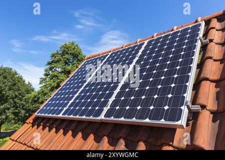 Row of blue solar panels on roof of house Stock Photo