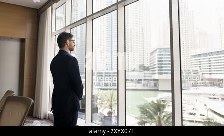 Serious confident business owner man in suit standing at window Stock Photo