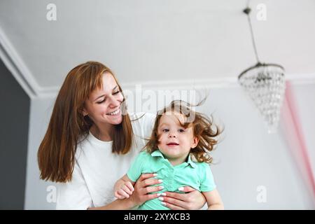 Young woman having fun with daughter indoors Stock Photo