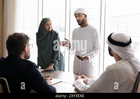 Couple of young Arabian managers presenting project to European partners Stock Photo