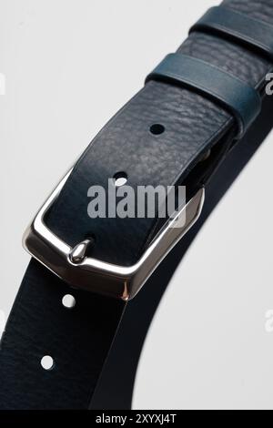 Part of a dark green leather classic belt with a buckle on a gray background. Stock Photo