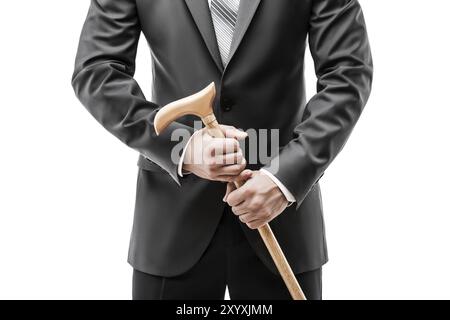 Businessman in black suit hand holding wooden walking cane stick white isolated Stock Photo