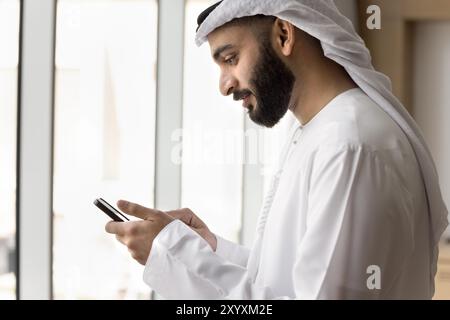 Positive young Arab businessman using wireless Internet communication Stock Photo