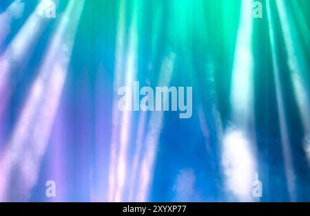 Blurred rays of light from stage spotlights on a purple-green background. Stock Photo