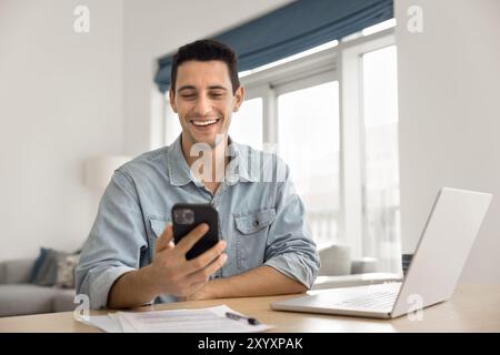 Cheerful handsome Latin entrepreneur man using mobile phone Stock Photo