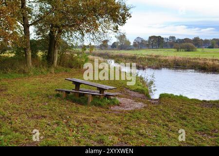 Wooden table and benches for relaxing close to river Stock Photo