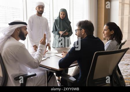 Diverse business team talking at meeting table Stock Photo