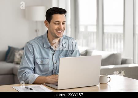 Cheerful handsome Latin freelance business man working at home Stock Photo