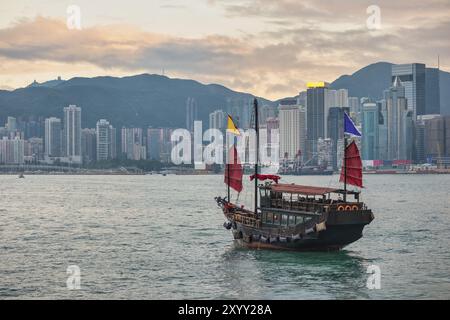 Hong Kong city skyline at Victoria Bay with junk boat and skyscraper business district Stock Photo