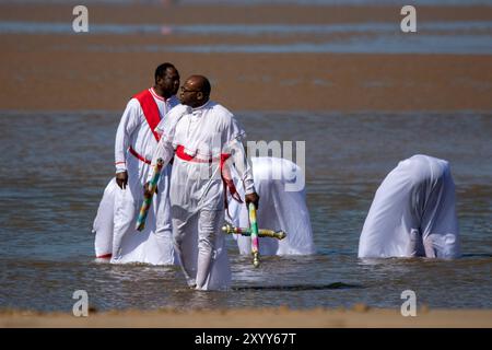 Jesus White Robe Biblical Red Sash ; Christian Group bathing in the sea in Southport, UK Stock Photo