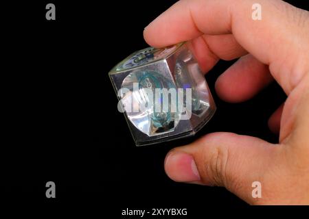 hands holding a vintage flash cube or Magicube from Sylvania brand on black background Stock Photo