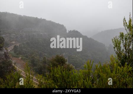 The viaduct on the 7 km long historic Lithgow Zig Zag railway line winds its way along steep cliffs, connecting Clarence station, a small town of Clar Stock Photo