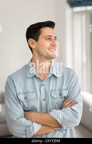 Happy young Latin man in casual shirt posing at home Stock Photo
