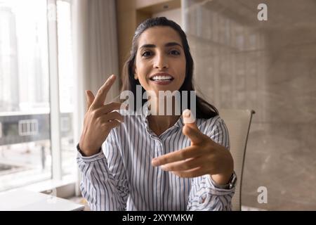 Positive Hispanic business coach woman giving online training Stock Photo