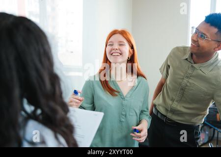 Contemporary co-working space with young professionals or students collaborating on projects, demonstrating teamwork. Stock Photo