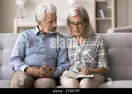 Man listening attentively his wife reading a book Stock Photo