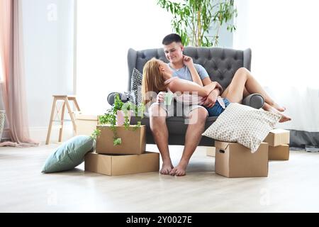 Young happy couple in room with moving boxes at new home Stock Photo