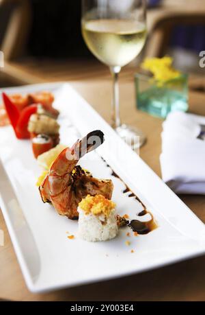 Roll set on the plate served at the restaurant with wine on the table Stock Photo