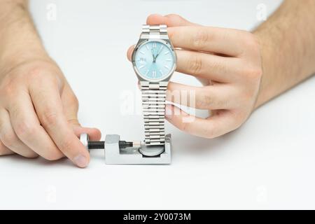 Adjusting watch strap with link remover tool Stock Photo - Alamy