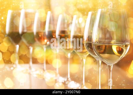 Different tasty wines in glasses on table. Bokeh effect Stock Photo