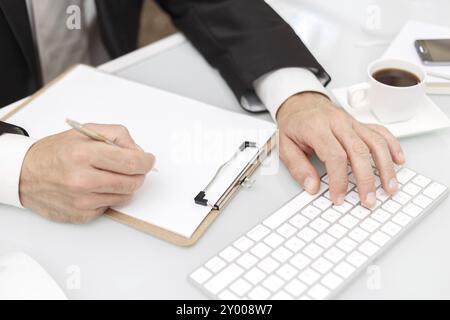 Male hands using modern computer and writing with pen business concept Stock Photo