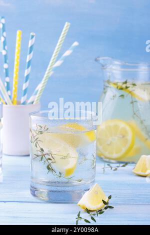 Cool beverage with lemon and thyme, on blue wooden background Stock Photo