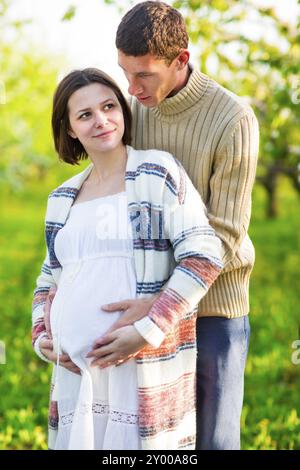 Portrait of a happy pregnant couple in the blossom garden Stock Photo