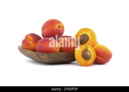 Pile of ripe apricots and one sliced in half to showcase its succulent interior, isolated on a white background Stock Photo