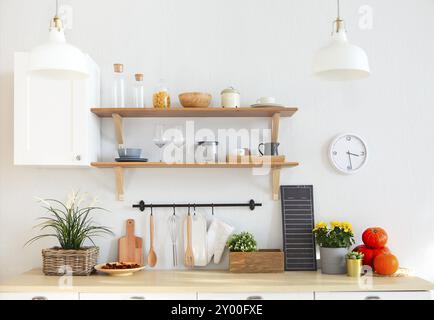 Interior of empty modern white kitchen with various objects on the table Stock Photo