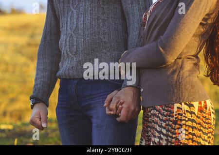 Young couple in love walking by the sea holding hand at sunset time Stock Photo