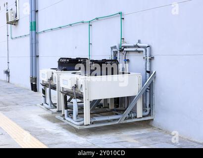 Condensing units of air conditioning systems, Condensing unit installed on the wall. Outdoor air conditioning and heat pump units. Stock Photo