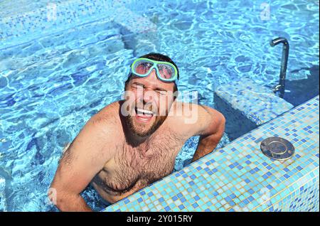 Funny man in diving mask jumping in pool, top view Stock Photo