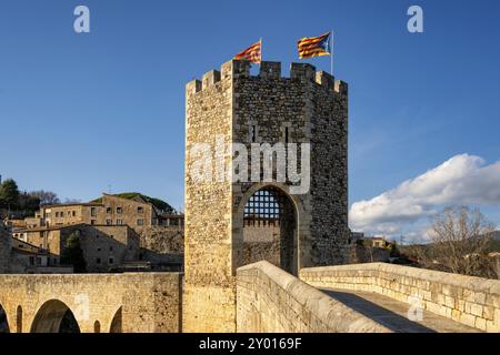 Besalu historic medieval city with Catalonia flags on the stone bridge tower crossing El Fluvia river, in Spain Stock Photo