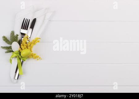 Easter dinner table setting on white wooden table, festive holiday background top view Stock Photo