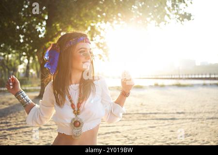 Happy slim tan woman in jeans dancing on the beach in sunset Stock Photo