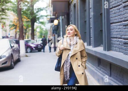 Middle age women goes through the city and smiles. Happiness concept Stock Photo