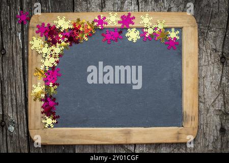 Christmas frame of confetti on vintage blackboard blank. Winter holidays concept Stock Photo