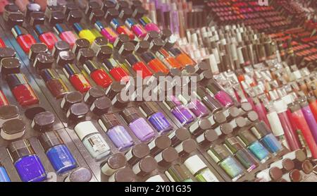 Set of various bright nail lacquers placed on stand in modern cosmetic shop Stock Photo