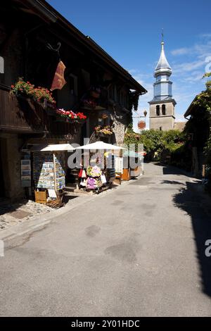 The stainless steel steeple of St. Pancras church is visible in the heart of Yvoire, a charming medieval stone village in France situation on Lake Gen Stock Photo