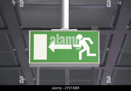 Green sign for emergency exit in a german railway station Stock Photo