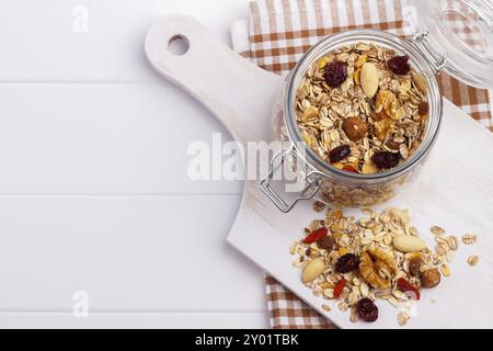 Bowl of homemade muesli with nuts, berries, dried fruits, glass of milk and honey. healthy breakfast. top view Stock Photo