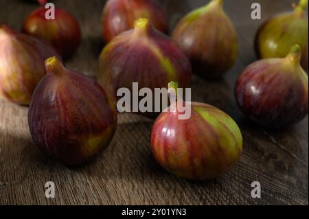 Ripe figs on a wooden background. Fresh harvest of figs on the background of the garden. Stock Photo