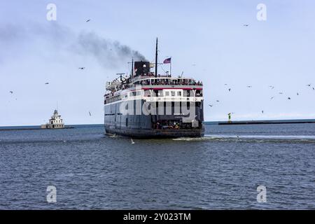 Manitowoc WI USA July 18 2023 : Ludington MI To Manitowoc WI SS Badger People Car Ferry. The ship sails past the lighthouse and leaves the dock in Man Stock Photo