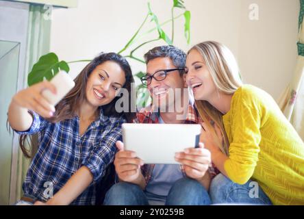 Business people conversation with technology at hand. Colleagues making selfei and having fun at the break Stock Photo