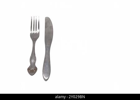 Metal fork and table knife on white isolated background. Horizontal. Stock Photo