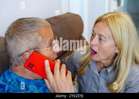 adult couple is surprised talking on the phone with family for good news Stock Photo