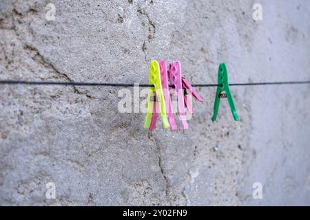 Plastic clothespin on line with grey wall Stock Photo